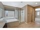 Bright bathroom featuring a soaking tub, glass-enclosed shower, and vanity with sink at 7963 Cape Brett St, Las Vegas, NV 89131
