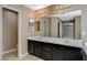 Modern bathroom boasts a double vanity, ample lighting, and tile flooring at 7963 Cape Brett St, Las Vegas, NV 89131