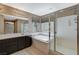 Bright bathroom featuring double vanity, soaking tub, and separate glass-enclosed shower at 7963 Cape Brett St, Las Vegas, NV 89131