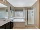 Well-lit bathroom with double vanity, soaking tub, and glass-enclosed shower at 7963 Cape Brett St, Las Vegas, NV 89131