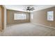 Spacious bedroom with neutral carpeting, ceiling fan, and multiple windows for natural light at 7963 Cape Brett St, Las Vegas, NV 89131