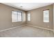 Neutral bedroom with beige carpet, three windows, and neutral paint creates a serene and comfortable atmosphere at 7963 Cape Brett St, Las Vegas, NV 89131