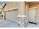 Close-up of the entry door and garage of a stucco home with stone accents at 7963 Cape Brett St, Las Vegas, NV 89131