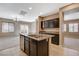 Open kitchen with island, stainless appliances and dishwasher, flowing into the carpeted living spaces at 7963 Cape Brett St, Las Vegas, NV 89131