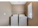 Practical laundry room with a washer, dryer, and shelving for storage at 7963 Cape Brett St, Las Vegas, NV 89131