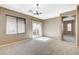 The living area has neutral walls and carpet with a sliding glass door and windows that provide ample light at 7963 Cape Brett St, Las Vegas, NV 89131