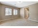 Large, carpeted living room with neutral paint and bright natural light from large windows at 7963 Cape Brett St, Las Vegas, NV 89131