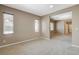 Bright living room with neutral walls and carpet with multiple windows bringing in natural light and an open floorplan at 7963 Cape Brett St, Las Vegas, NV 89131