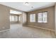 Spacious living room with plush carpeting, neutral paint, and two large windows at 7963 Cape Brett St, Las Vegas, NV 89131