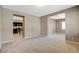 Open living area showcases neutral tones and carpet, seamlessly connecting to the adjacent kitchen with dark cabinetry at 7963 Cape Brett St, Las Vegas, NV 89131