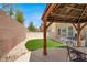 Landscaped backyard features a dining area, faux grass, and a privacy fence at 8015 Maple Park St, Las Vegas, NV 89131
