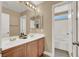Bathroom featuring double sinks, wood cabinets, a large mirror, and tub with shower at 8015 Maple Park St, Las Vegas, NV 89131