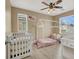 Bedroom with a crib and a play bed in front of two windows and a ceiling fan at 8015 Maple Park St, Las Vegas, NV 89131
