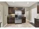 Functional kitchen with stainless steel refrigerator, ample cabinet space, and easy access to other rooms at 8015 Maple Park St, Las Vegas, NV 89131