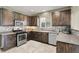 Cozy kitchen with dark wood cabinets, stainless steel appliances, and a tiled backsplash at 8015 Maple Park St, Las Vegas, NV 89131