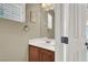 Powder room boasts a wood vanity, white countertop, and a well-lit mirror at 8015 Maple Park St, Las Vegas, NV 89131