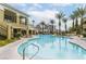 Beautiful community pool surrounded by palm trees and lounge chairs at 8777 Maule Ave # 3116, Las Vegas, NV 89148
