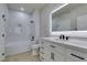 This is a modern bathroom with a white vanity, black hardware, and a shower-tub combo at 9050 W Warm Springs Rd # 1117, Las Vegas, NV 89148