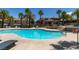 Large community pool surrounded by well-manicured landscaping, palm trees, and lounge areas at 9050 W Warm Springs Rd # 1117, Las Vegas, NV 89148