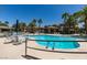 A clear blue community pool is surrounded by palm trees, lounge chairs, and patio seating at 9050 W Warm Springs Rd # 1117, Las Vegas, NV 89148
