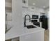 Modern kitchen featuring a quartz countertop, black appliances, and white cabinets at 9050 W Warm Springs Rd # 1117, Las Vegas, NV 89148