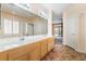 Bathroom featuring double sinks, walk-in shower, soaking tub, and an entryway to the bedroom at 940 Rifle Dr, Henderson, NV 89002