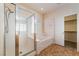 Bright bathroom with a glass-enclosed shower, soaking tub, and access to the walk-in closet at 940 Rifle Dr, Henderson, NV 89002