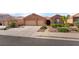 Charming single-story home with a three-car garage, desert landscaping, and neutral color palette at 940 Rifle Dr, Henderson, NV 89002