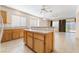 Bright kitchen featuring a breakfast bar, tile flooring, wood cabinets, and an open view to the living area at 940 Rifle Dr, Henderson, NV 89002