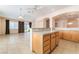 Open concept kitchen showing breakfast bar, tile floors, and access to the living room and backyard at 940 Rifle Dr, Henderson, NV 89002