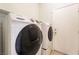 Functional laundry area with side-by-side washer and dryer units next to a door at 940 Rifle Dr, Henderson, NV 89002