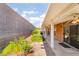 View of a covered patio with block wall and landscaped garden including some shrubs and flowers at 940 Rifle Dr, Henderson, NV 89002