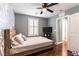 Cozy bedroom with wood-look floors, a ceiling fan, and a decorative statement wall at 10229 Mayflower Bay Ave, Las Vegas, NV 89166