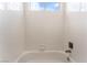 Bright white tiled bath and shower at 10505 Jeremy Ridge Ave, Las Vegas, NV 89144