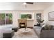 Cozy living room with a stone fireplace, modern decor, and sliding glass door at 10505 Jeremy Ridge Ave, Las Vegas, NV 89144