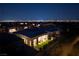 Aerial view of community showcasing modern homes, landscaping, and the city skyline at night at 10781 Agate Cliffs Ave, Las Vegas, NV 89135