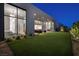 Stunning backyard at twilight with lush lawn, modern architecture, and seamless indoor-outdoor living at 10781 Agate Cliffs Ave, Las Vegas, NV 89135