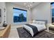 This bedroom offers a large window with neighborhood views and a sleek ceiling light for an inviting space at 10781 Agate Cliffs Ave, Las Vegas, NV 89135