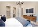 Bright bedroom featuring wood floors, a modern light fixture, and en suite bathroom and closet access at 10781 Agate Cliffs Ave, Las Vegas, NV 89135