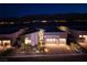 Striking home exterior with a three-car garage, modern design, and manicured landscaping at dusk at 10781 Agate Cliffs Ave, Las Vegas, NV 89135