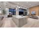 Modern, open kitchen with island, stainless appliances, and seamless flow to living and dining areas at 10781 Agate Cliffs Ave, Las Vegas, NV 89135