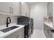 Well-appointed laundry room featuring modern washer and dryer, ample cabinetry and countertop space, and a sink at 10781 Agate Cliffs Ave, Las Vegas, NV 89135