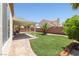 Serene backyard oasis with artificial turf, a covered patio, and lush greenery at 1515 Horizon Crest Ct, Henderson, NV 89012