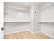 Spacious walk-in closet featuring custom shelving and wood flooring at 1515 Horizon Crest Ct, Henderson, NV 89012