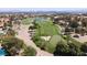 Expansive aerial view of lush golf course, water features, mature trees, and a beautiful cityscape in the background at 1813 Skyline Dr, Las Vegas, NV 89117