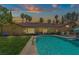 Back of house with tile roof, beautiful backyard and pool with mature palm trees in the distance at 1813 Skyline Dr, Las Vegas, NV 89117