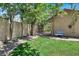 A serene backyard with lush green grass, decorative rock border, and a quaint wrought iron gate at 1813 Skyline Dr, Las Vegas, NV 89117