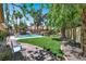 Beautiful backyard featuring a pool with a rock waterfall, mature trees, and lush landscaping at 1813 Skyline Dr, Las Vegas, NV 89117
