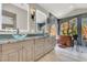 Stylish bathroom featuring dual vessel sinks, granite countertops, and a modern soaking tub by a window at 1813 Skyline Dr, Las Vegas, NV 89117