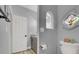 Modern half-bathroom with neutral paint, wood-look floors, and decorative arched niche beside the toilet at 1813 Skyline Dr, Las Vegas, NV 89117